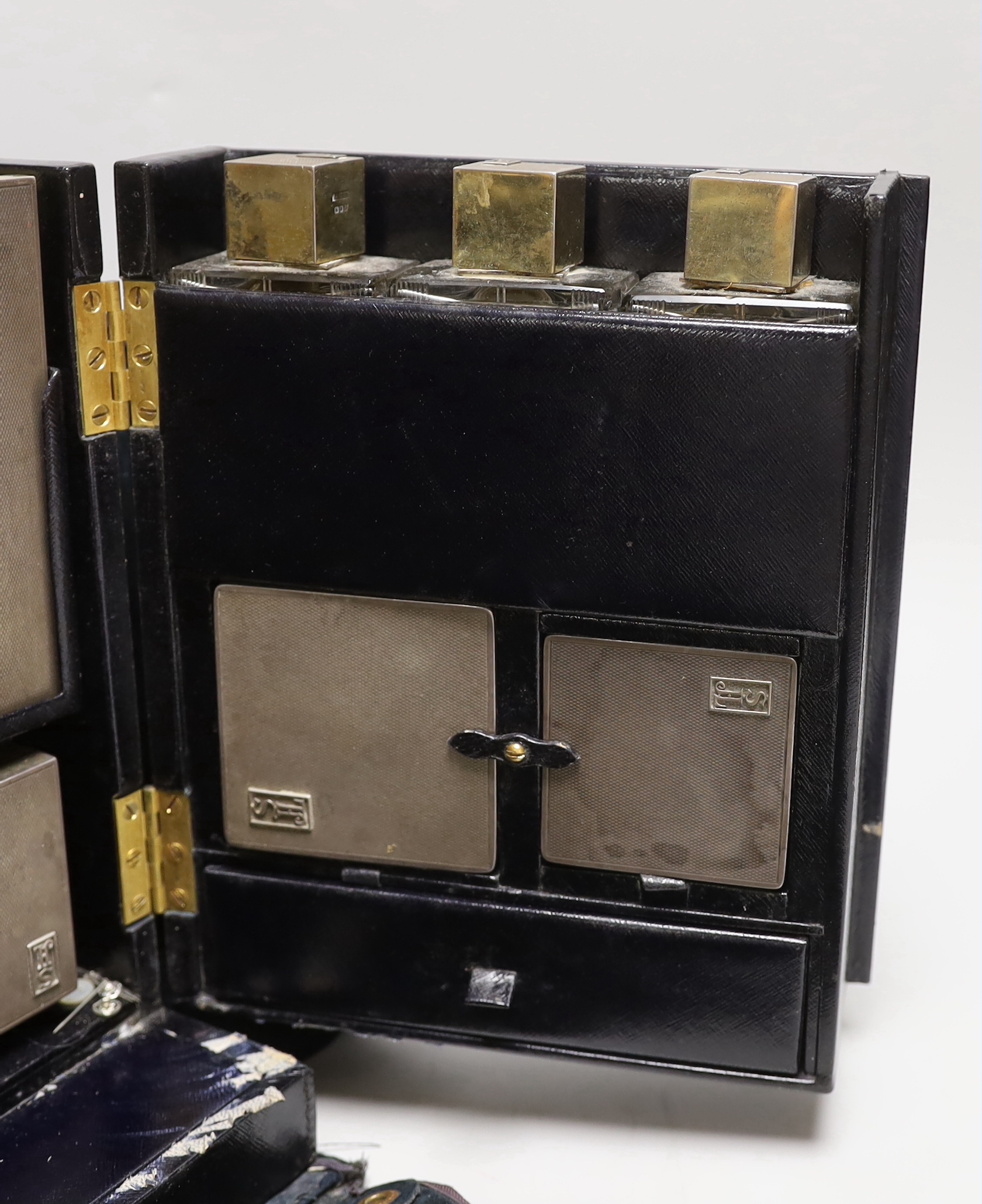 A George VI leather travelling vanity case, containing seventeen monogrammed silver mounted items, including ten mounted glass toilet jars, two boxes, four brushes and a hand mirror, Asprey & Co, London, 1936, case width
